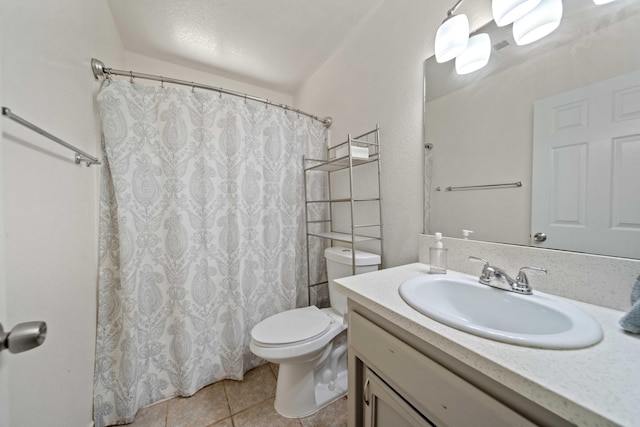 bathroom with tile patterned flooring, vanity, and toilet