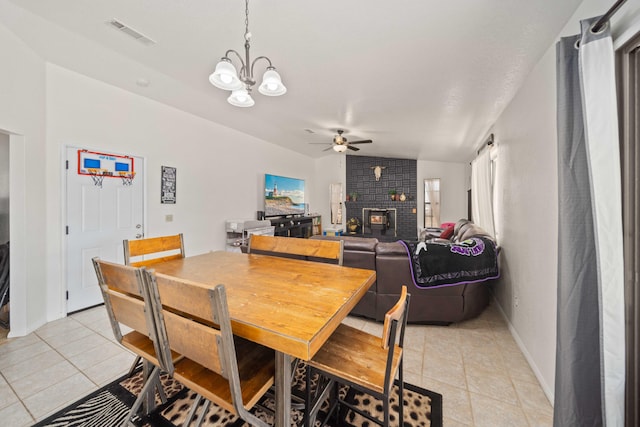 dining space featuring a fireplace, light tile patterned floors, ceiling fan with notable chandelier, and lofted ceiling