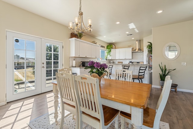 dining space featuring a chandelier, french doors, light wood finished floors, recessed lighting, and baseboards