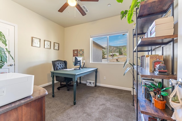 carpeted office space with ceiling fan and baseboards
