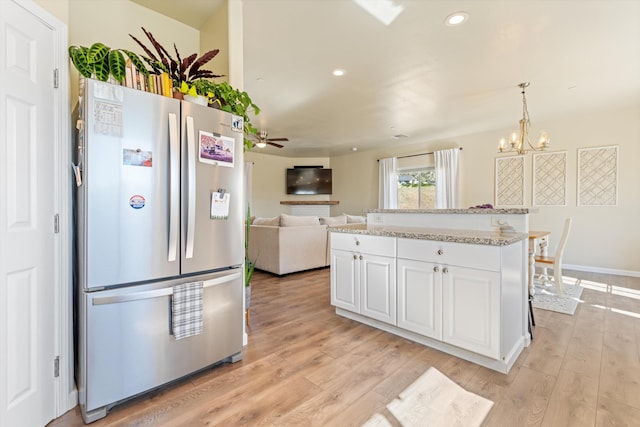 kitchen with freestanding refrigerator, a chandelier, white cabinets, light wood finished floors, and ceiling fan