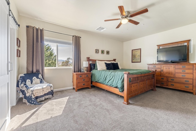 bedroom featuring carpet floors, ceiling fan, and a barn door