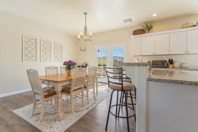 dining space with a chandelier, dark wood-type flooring, recessed lighting, and baseboards