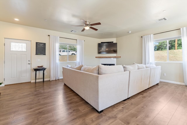 living area featuring ceiling fan, wood finished floors, a fireplace, baseboards, and recessed lighting