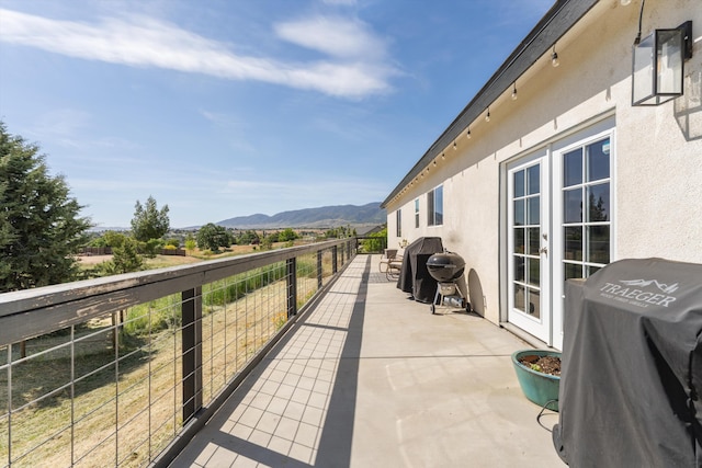 view of patio / terrace featuring a balcony, a mountain view, and grilling area