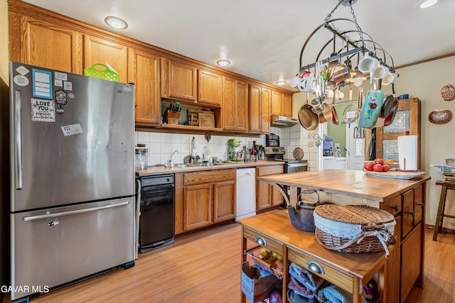 24750 Flatiron Ct, Tehachapi, CA 93561 - kitchen featuring appliances with stainless steel finishes, light wood-style floors, backsplash, and under cabinet range hood