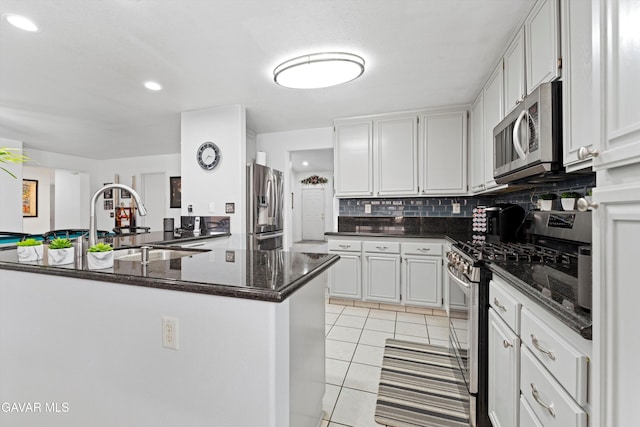 3267 Desert Cloud Ave, Rosamond, CA 93560 - kitchen featuring appliances with stainless steel finishes, light tile patterned floors, decorative backsplash, white cabinets, and recessed lighting