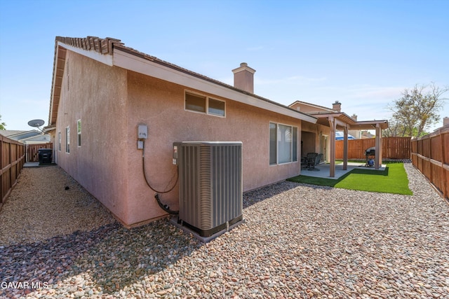 3267 Desert Cloud Ave, Rosamond, CA 93560 - back of house featuring a patio, a fenced backyard, stucco siding, and a chimney