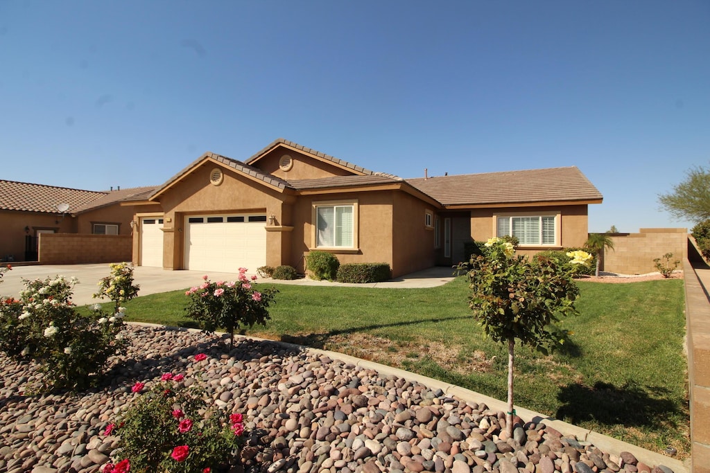 view of front of house featuring a garage and a front lawn