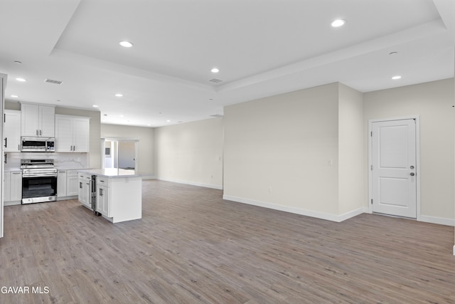 9207 Margery Ave, California City, CA 93505 - kitchen with appliances with stainless steel finishes, open floor plan, light wood-type flooring, recessed lighting, and a tray ceiling