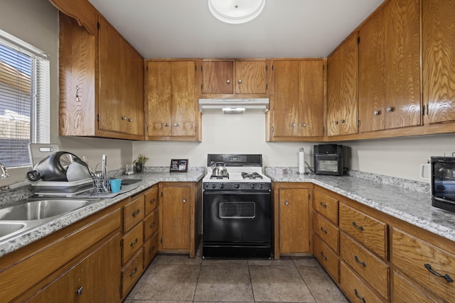 kitchen featuring range with gas cooktop, tile patterned flooring, and sink