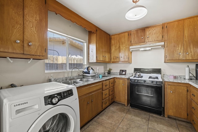 kitchen featuring gas range oven, washer / clothes dryer, light tile patterned flooring, and sink