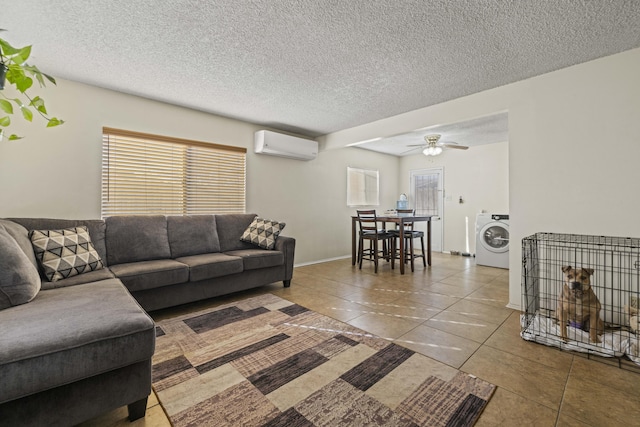 tiled living room with washer / dryer, an AC wall unit, a textured ceiling, and ceiling fan