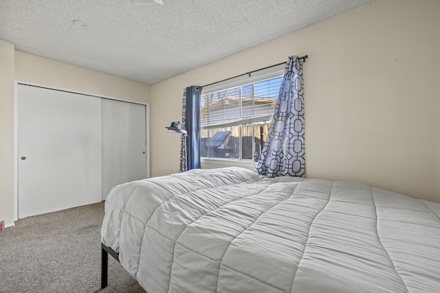 bedroom featuring light colored carpet, a closet, and a textured ceiling