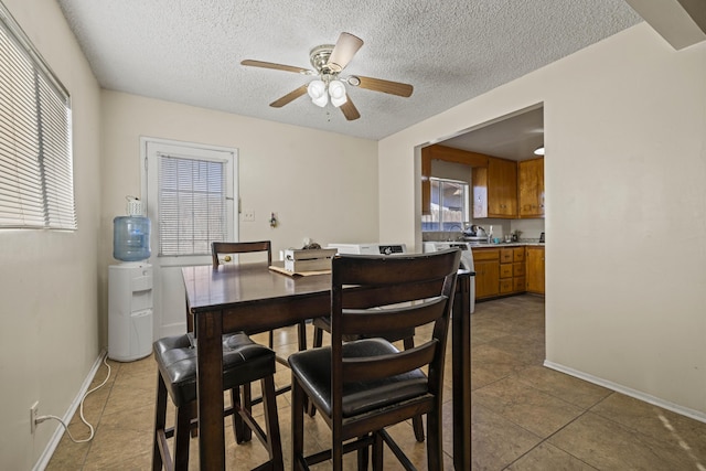 dining area with a textured ceiling, ceiling fan, and light tile patterned floors