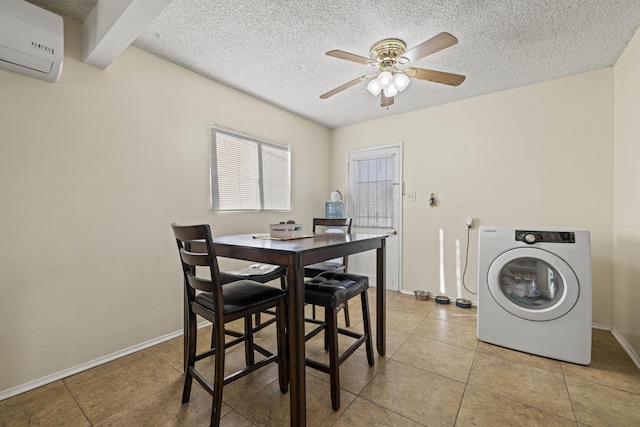 tiled dining space featuring ceiling fan, a wall mounted AC, washer / dryer, and a textured ceiling