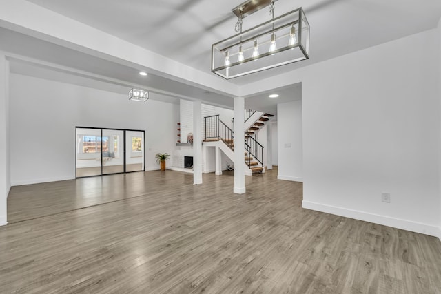 unfurnished living room with hardwood / wood-style floors and a brick fireplace