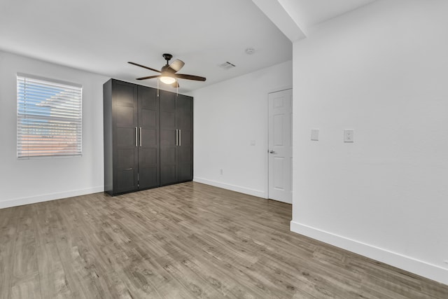 unfurnished bedroom with ceiling fan, light hardwood / wood-style floors, and a closet