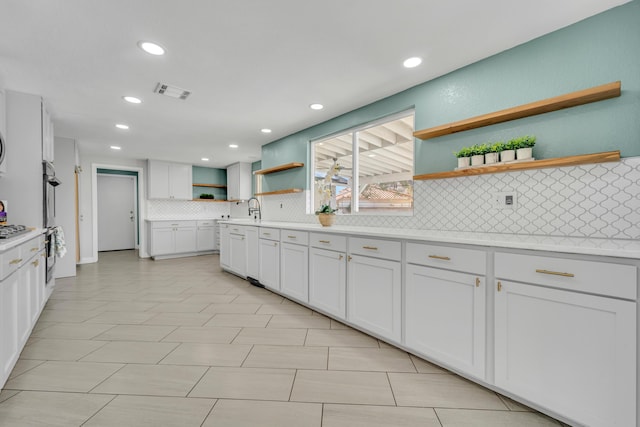 kitchen with white cabinetry, sink, tasteful backsplash, and stainless steel gas stovetop