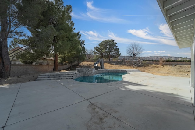 view of swimming pool with a water slide and a patio area