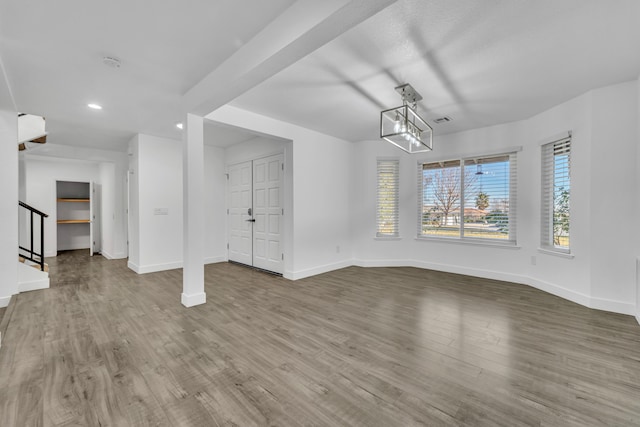 unfurnished dining area with wood-type flooring and a chandelier