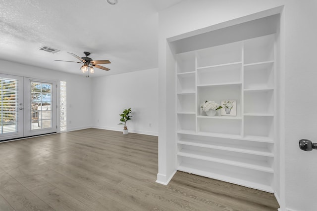 unfurnished living room featuring hardwood / wood-style floors, french doors, and ceiling fan