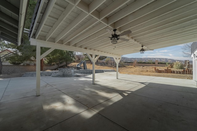 view of patio with ceiling fan and a mountain view