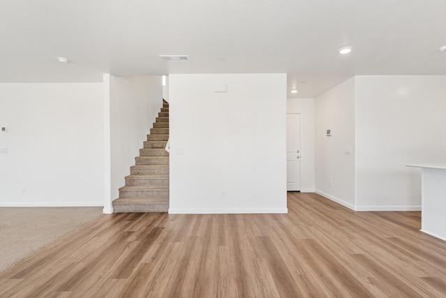 6018 Vespucci Ave, Bakersfield, CA 93313 - unfurnished living room featuring stairway, baseboards, light wood-style floors, and recessed lighting