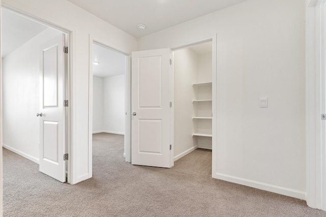 6018 Vespucci Ave, Bakersfield, CA 93313 - corridor with light carpet and baseboards