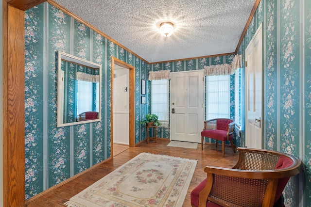 2600 Aland St, Lancaster, CA 93536 - foyer with wallpapered walls, a textured ceiling, wood finished floors, and ornamental molding