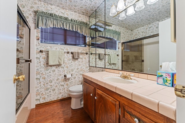 2600 Aland St, Lancaster, CA 93536 - full bathroom featuring wallpapered walls, wood finished floors, toilet, vanity, and bath / shower combo with glass door