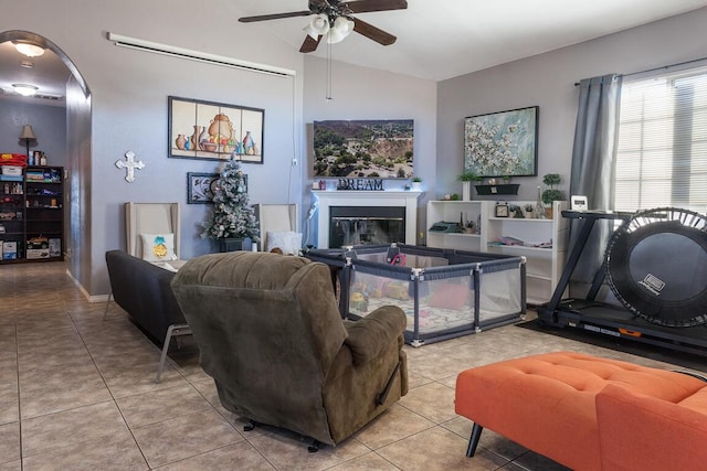 tiled living room with ceiling fan and vaulted ceiling