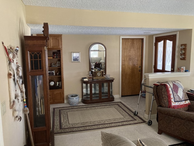 carpeted entrance foyer featuring a textured ceiling