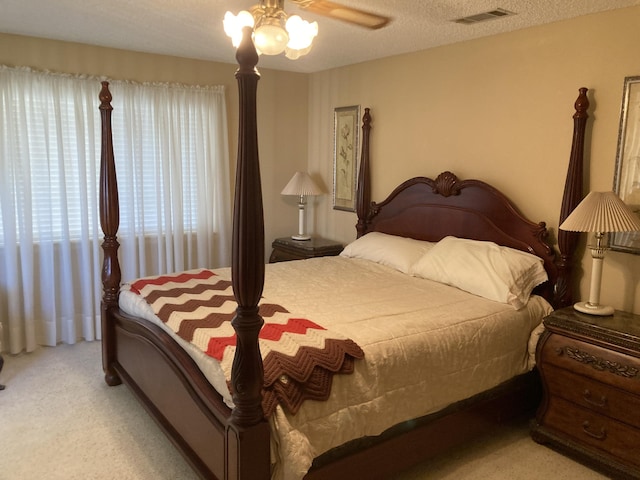 carpeted bedroom with a textured ceiling and ceiling fan