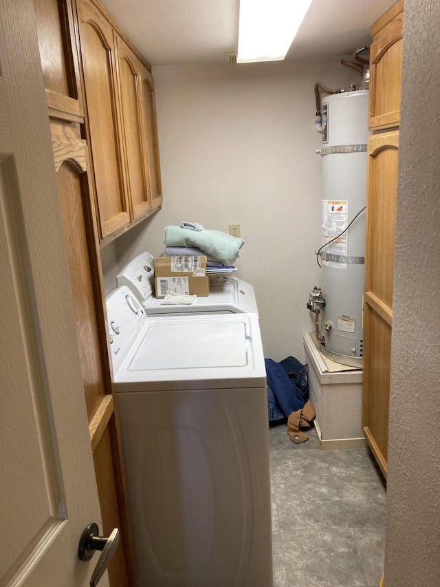 washroom featuring cabinets, strapped water heater, and washing machine and dryer