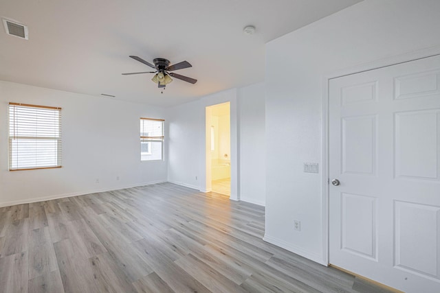 unfurnished room featuring light wood-style floors, visible vents, baseboards, and a ceiling fan
