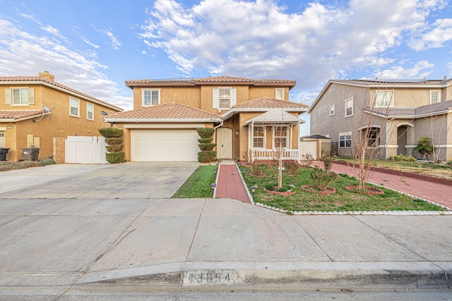 view of front of house with driveway, a tiled roof, an attached garage, fence, and stucco siding