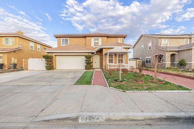 view of front of house with driveway, a tiled roof, an attached garage, fence, and stucco siding