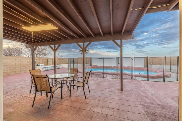 view of patio featuring outdoor dining area, a fenced backyard, and a fenced in pool