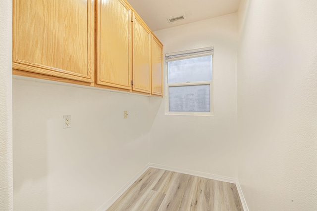 washroom with light wood finished floors, visible vents, and baseboards