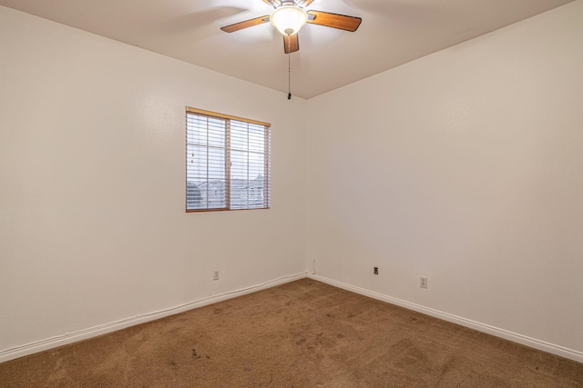 unfurnished room with a ceiling fan, carpet, and baseboards