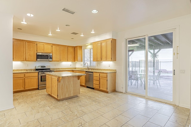 kitchen featuring a breakfast bar, recessed lighting, visible vents, appliances with stainless steel finishes, and a kitchen island