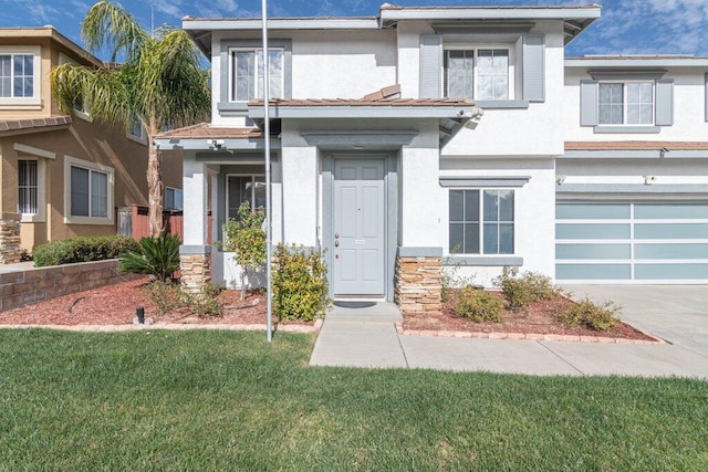 view of front of house with an attached garage, driveway, a front lawn, and stucco siding