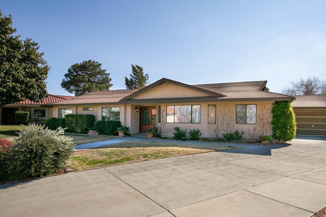 ranch-style house featuring a garage and a front lawn