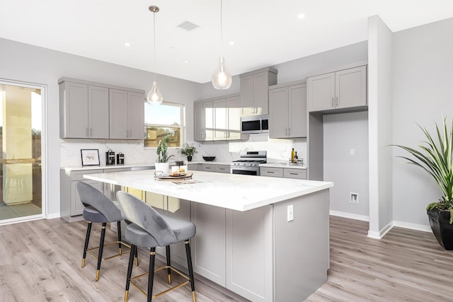 40127 Pevero Ct, Palmdale, CA 93551 - kitchen with appliances with stainless steel finishes, gray cabinets, a center island, light wood-style flooring, and recessed lighting