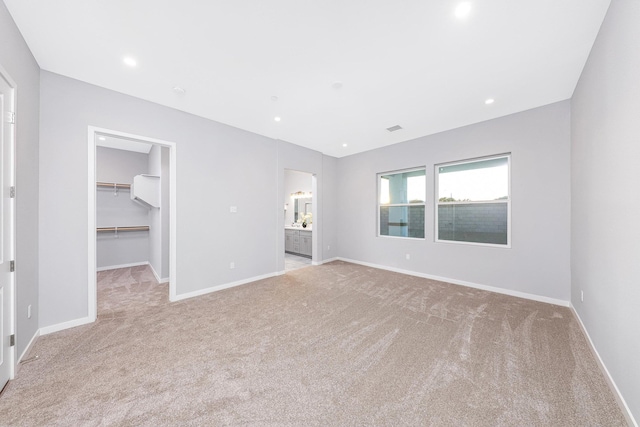 40127 Pevero Ct, Palmdale, CA 93551 - unfurnished bedroom featuring light carpet, a walk in closet, a closet, ensuite bath, and recessed lighting