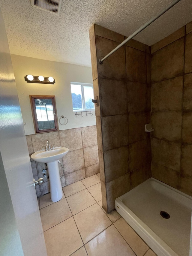 2010 W Lumber St, Lancaster, CA 93536 - full bath with tile walls, a stall shower, a textured ceiling, and tile patterned flooring