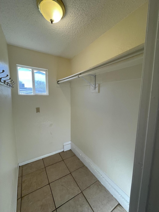 2010 W Lumber St, Lancaster, CA 93536 - laundry room with a textured ceiling, tile patterned floors, and baseboards