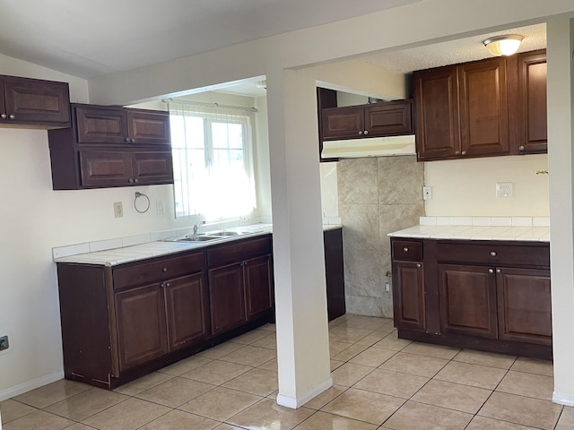 2010 W Lumber St, Lancaster, CA 93536 - kitchen featuring a sink, light tile patterned floors, dark brown cabinets, and baseboards