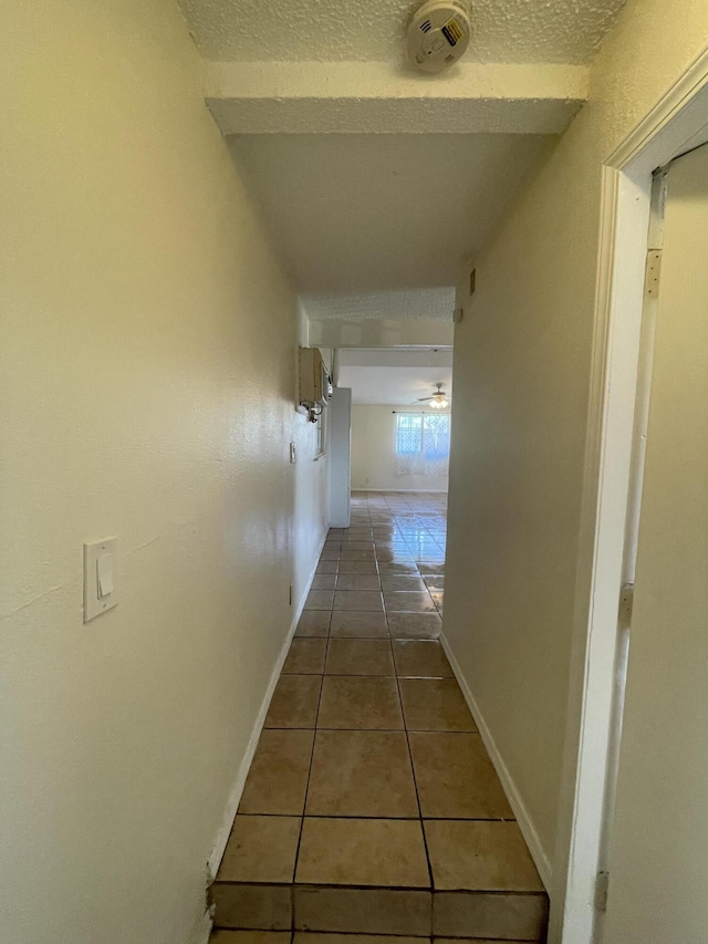 2010 W Lumber St, Lancaster, CA 93536 - corridor with tile patterned flooring, a textured ceiling, and baseboards